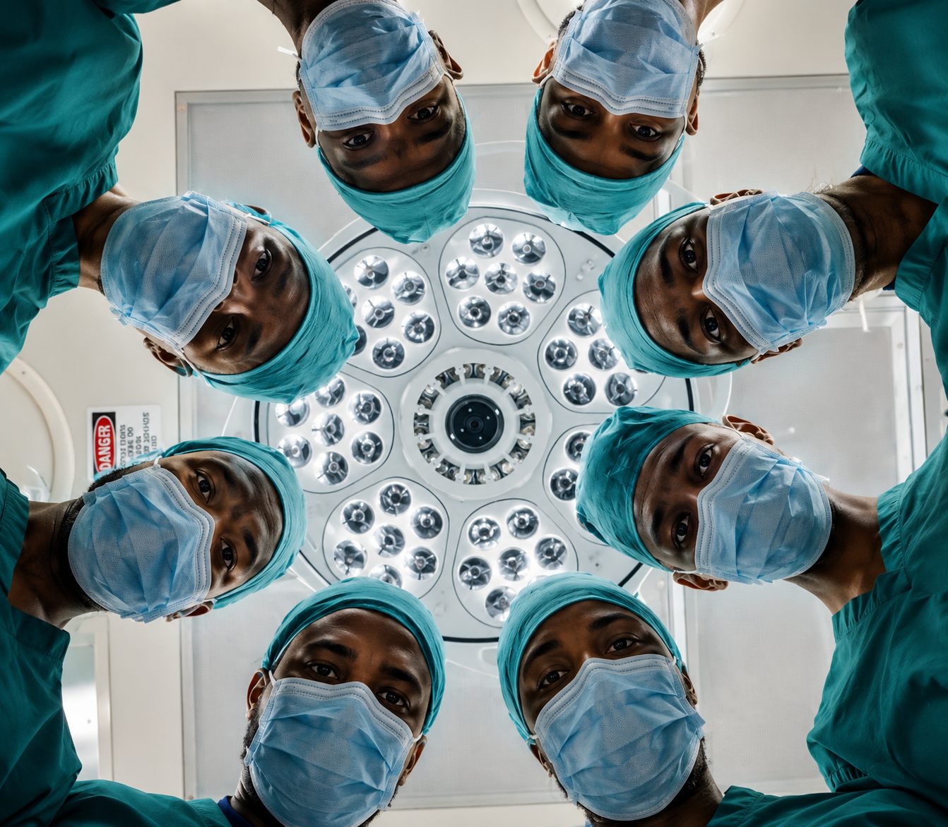 The Ndengera CBC Polyclinic theatre team gathered around the operating light